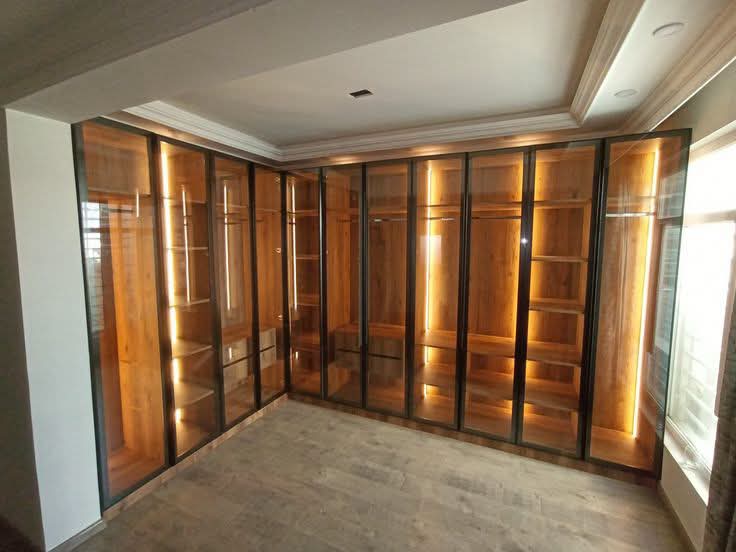 Dressing walk-in avec portes vitrées et éclairage LED, réalisé par RSS Studio